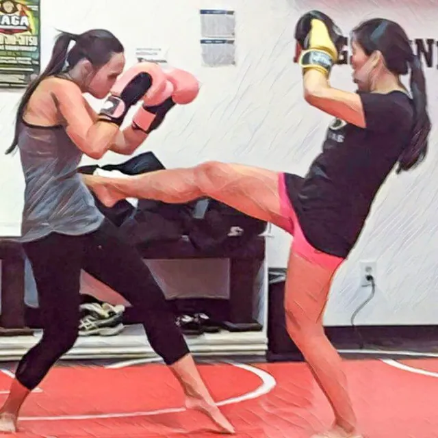 A fitness kickboxing class hitting heavy bags at Aces Jiu Jitsu Club